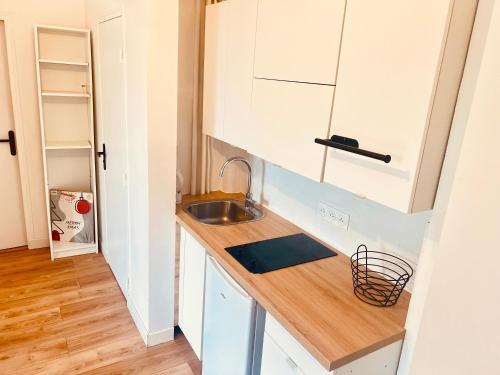 une cuisine avec un évier et un plan de travail en bois dans l'établissement Cozy apartment between Paris & Disneyland, à Le Perreux-Sur-Marne