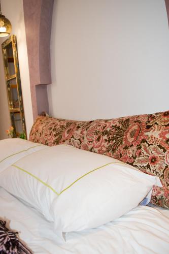a white pillow sitting on top of a bed at Riad Le Khan Mogador in Essaouira