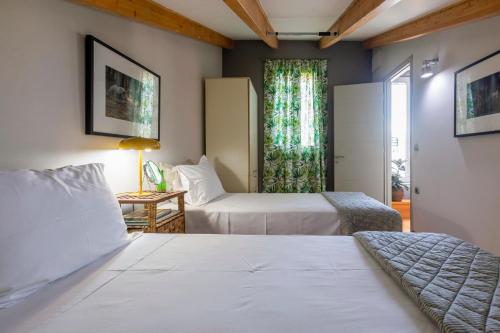 a hotel room with two beds and a window at Artist Loft in Corfu