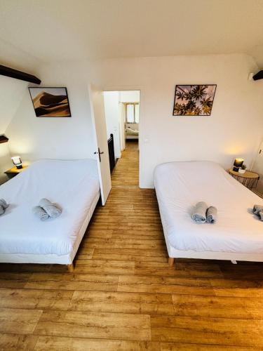 deux lits dans une chambre avec parquet dans l'établissement Le Pavillon G aillard - Maison de 5 chambres, à Gien