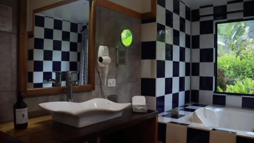 a bathroom with a sink and a bath tub at Las Terrazas de Dana Boutique Lodge & Spa in Mindo