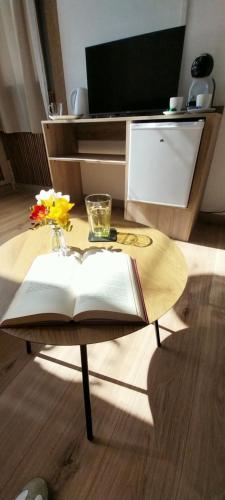 a coffee table with an open book on it at PILGRIMSROOM la Parada Del Camino in Negreira
