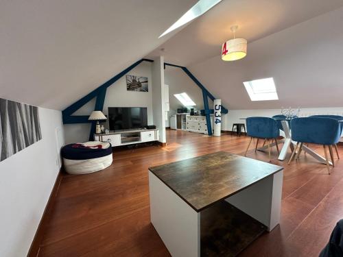 un salon avec une table et des chaises bleues dans l'établissement Captain YOO - Régate- Sentir les embruns vue/port, à Fécamp