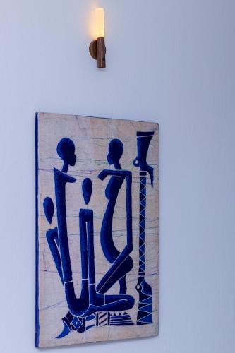 a blue painting of people on a wall with a candle at Le Rooftop Apparte - Barbecue, Grande Terrasse in Nabeul