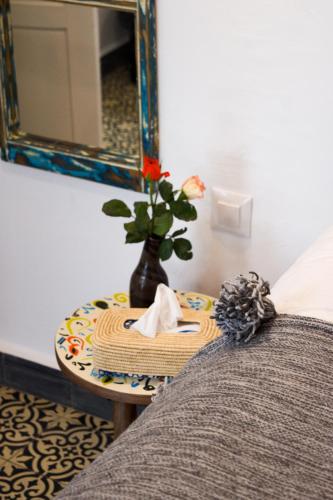 a table with a vase with a flower on it at Riad Le Khan Mogador in Essaouira