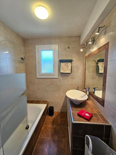 une salle de bain avec une baignoire et un lavabo et une baignoire dans l'établissement Au Farniente, à Vallauris