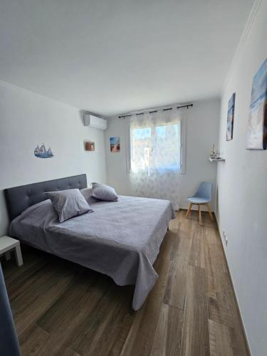 une chambre blanche avec un lit et une chaise dans l'établissement Au Farniente, à Vallauris