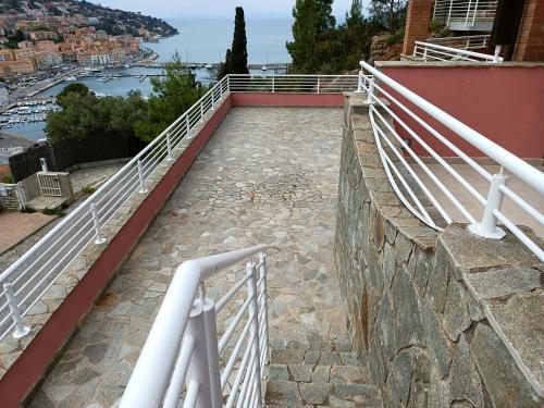 ポルト・サント・ステーファノにあるLuxury beach houseの建物の側面に白い欄干がある橋