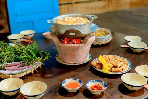 een tafel met daarop borden en kommen met eten bij Homestay Cô Hai in Xóm Rạch Già
