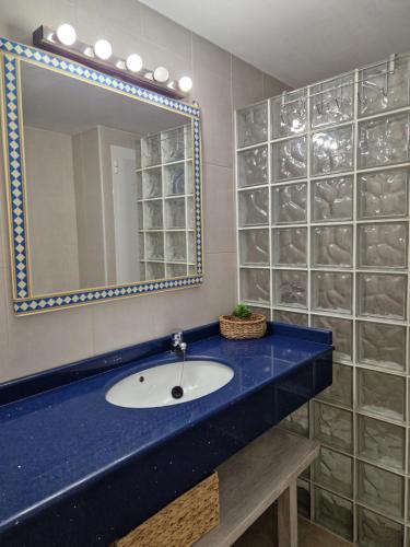 a bathroom with a sink and a mirror at Mirada Ponent in Es Pujols