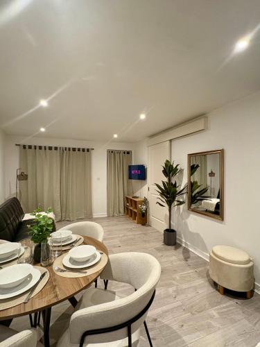 a living room with a table and chairs and a couch at Modern Apartment - Free Parking in London
