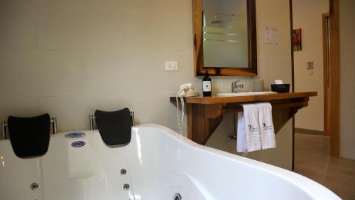a bathroom with a tub and a sink and a mirror at Las Terrazas de Dana Boutique Lodge & Spa in Mindo