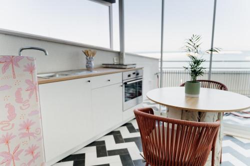 a kitchen with a table and chairs and a sink at Versace on the floor Water suite in Bisceglie