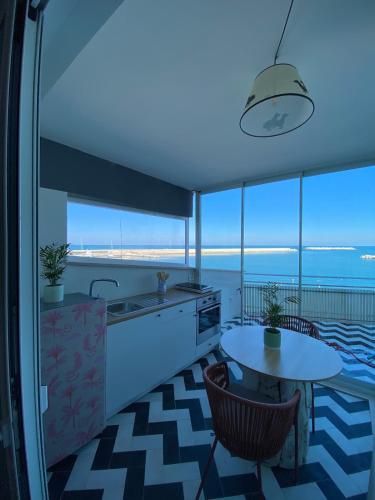 a kitchen with a sink and a table with chairs at Versace on the floor Water suite in Bisceglie