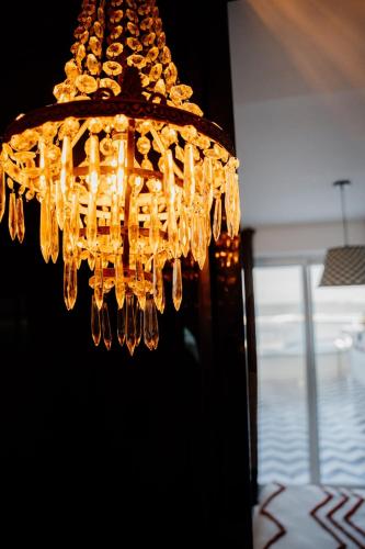 a chandelier hanging from the ceiling in a room at Versace on the floor Water suite in Bisceglie