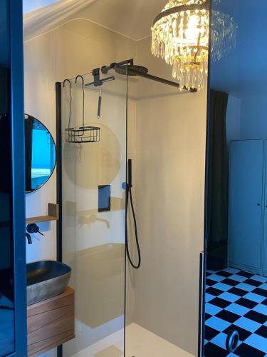a bathroom with a glass shower with a sink at Versace on the floor Water suite in Bisceglie