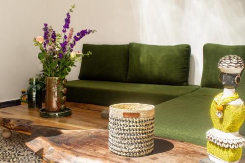 a living room with a green couch and a table at Riad Le Khan Mogador in Essaouira