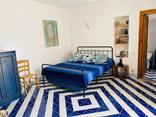 a bedroom with a bed and a blue and white floor at Casa Mandarino - central, see view and silence in Stromboli