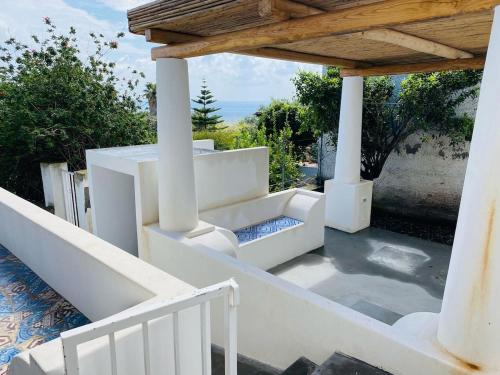 a porch with white columns and a wooden roof at Casa Mandarino - central, see view and silence in Stromboli