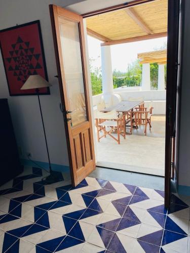 a room with a door and a table with chairs at Casa Mandarino - central, see view and silence in Stromboli