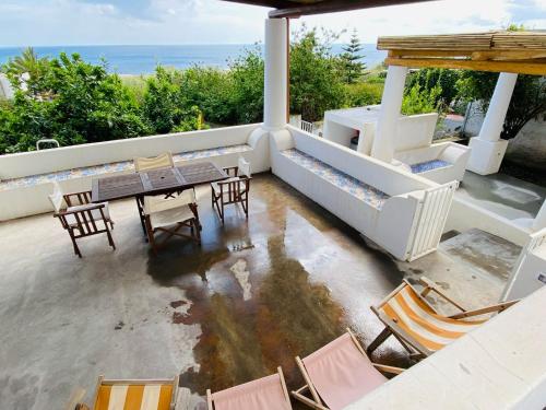 an outdoor patio with chairs and tables and the ocean at Casa Mandarino - central, see view and silence in Stromboli