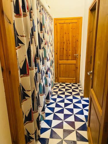 a hallway with a blue and white tiled floor at Casa Mandarino - central, see view and silence in Stromboli
