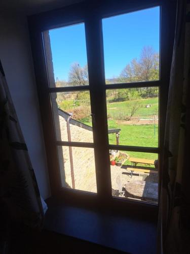 a window looking out at a view of a field at Art Tout in Fontenoille