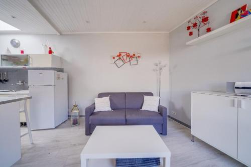 a living room with a couch and a table at Maison Papavero in La Teste-de-Buch