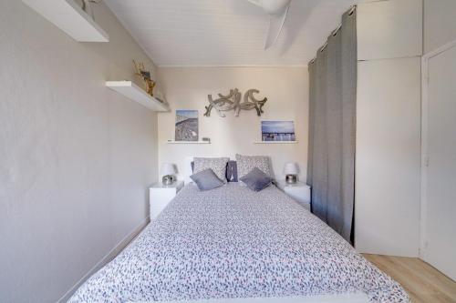 a bedroom with a large bed with blue pillows at Maison Papavero in La Teste-de-Buch