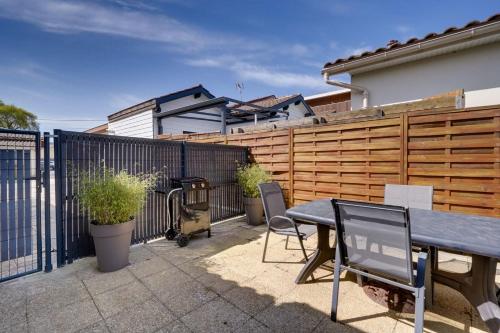 une terrasse avec une clôture en bois, une table et des chaises dans l'établissement Maison Papavero, à La Teste-de-Buch