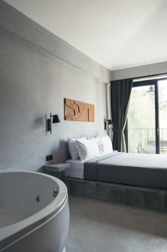 a bedroom with a bed and a bath tub and a tub at Primus Nefes Adult Only in Alacati