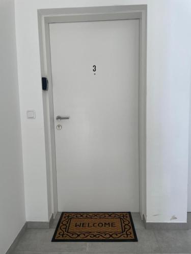 a door with a welcome mat in front of it at Neubauwohnung in LINZ - sehr zentral,gratis Parkplatz und Balkon in Linz