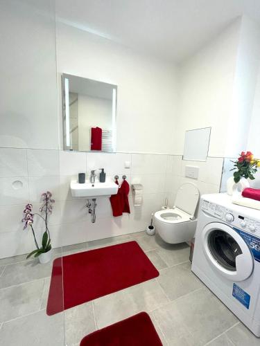 a bathroom with a washing machine and a red rug at Neubauwohnung in LINZ - sehr zentral,gratis Parkplatz und Balkon in Linz