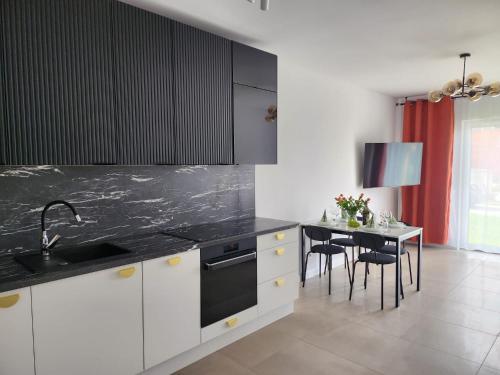 a kitchen with a sink and a table with chairs at Apartament Zielony Taras in Zgorzelec