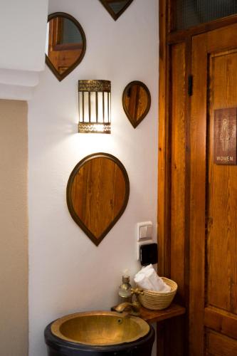 a bathroom with a sink and mirrors on the wall at Riad Le Khan Mogador in Essaouira