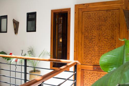a wooden door on a balcony with a plant at Riad Le Khan Mogador in Essaouira