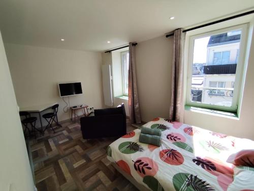 une chambre avec un lit, un bureau et une fenêtre dans l'établissement L'ibis City By Nid 'ouest, à Quimper