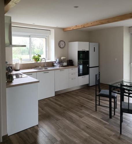 - une cuisine avec des appareils électroménagers blancs et une table à manger dans l'établissement Domaine Puy Saint Jammes, à Castres