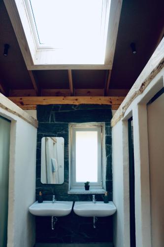 a bathroom with two sinks and a window at Ananda Guesthouse AL in Ourondo