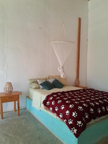 a bedroom with a bed with a blanket on it at Casa Moksha in Máncora