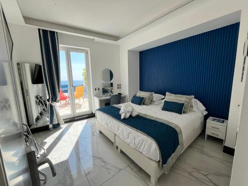 a bedroom with a large bed with a blue wall at Positano Art Hotel Pasitea in Positano