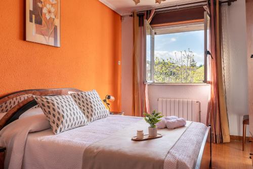 - une chambre avec des murs orange, un lit et une fenêtre dans l'établissement El estanque, à Galizano