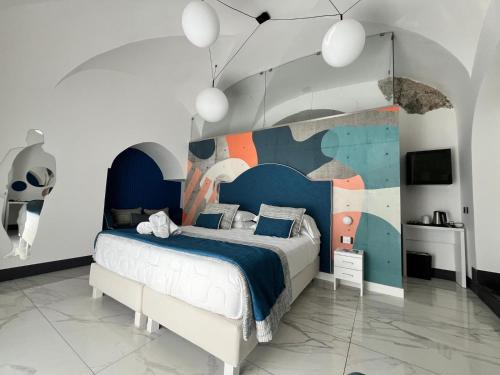 a bedroom with a bed with a painting on the wall at Positano Art Hotel Pasitea in Positano