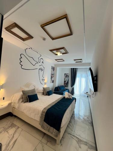 a bedroom with a bed with a drawing on the wall at Positano Art Hotel Pasitea in Positano