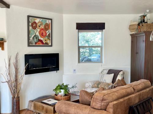 a living room with a couch and a flat screen tv at Prickly Pear Unique Studio with bathroom built into the Granite boulders, Amazing Views, Front & back porches, Firepit,Dog friendly in Prescott