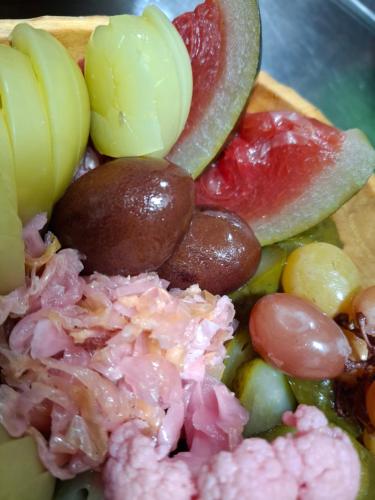 a plate of food with grapes meat and vegetables at Pensiunea CASA MOLDOVEANA in Piatra Neamţ