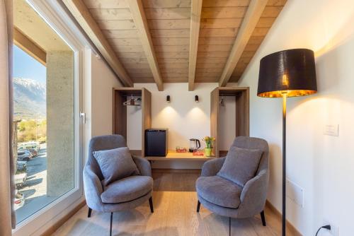 two chairs and a lamp in a room with a window at Residenza Sassella in Sondrio