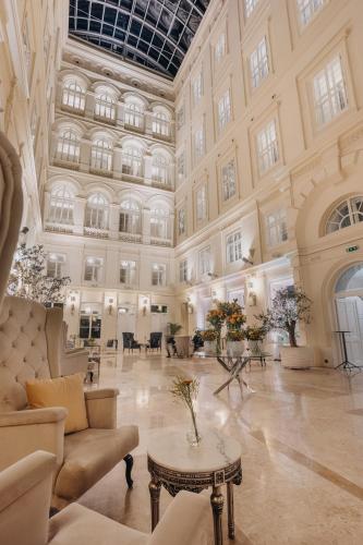 a large lobby with a large ceiling and a table at Grand Palace Brno - Czech Leading Hotels in Brno