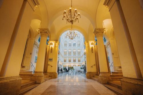 a large hallway with a chandelier in a building at Grand Palace Brno - Czech Leading Hotels in Brno