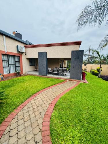 a brick walkway in front of a house at Dulelo Guest House Gaborone in Gaborone